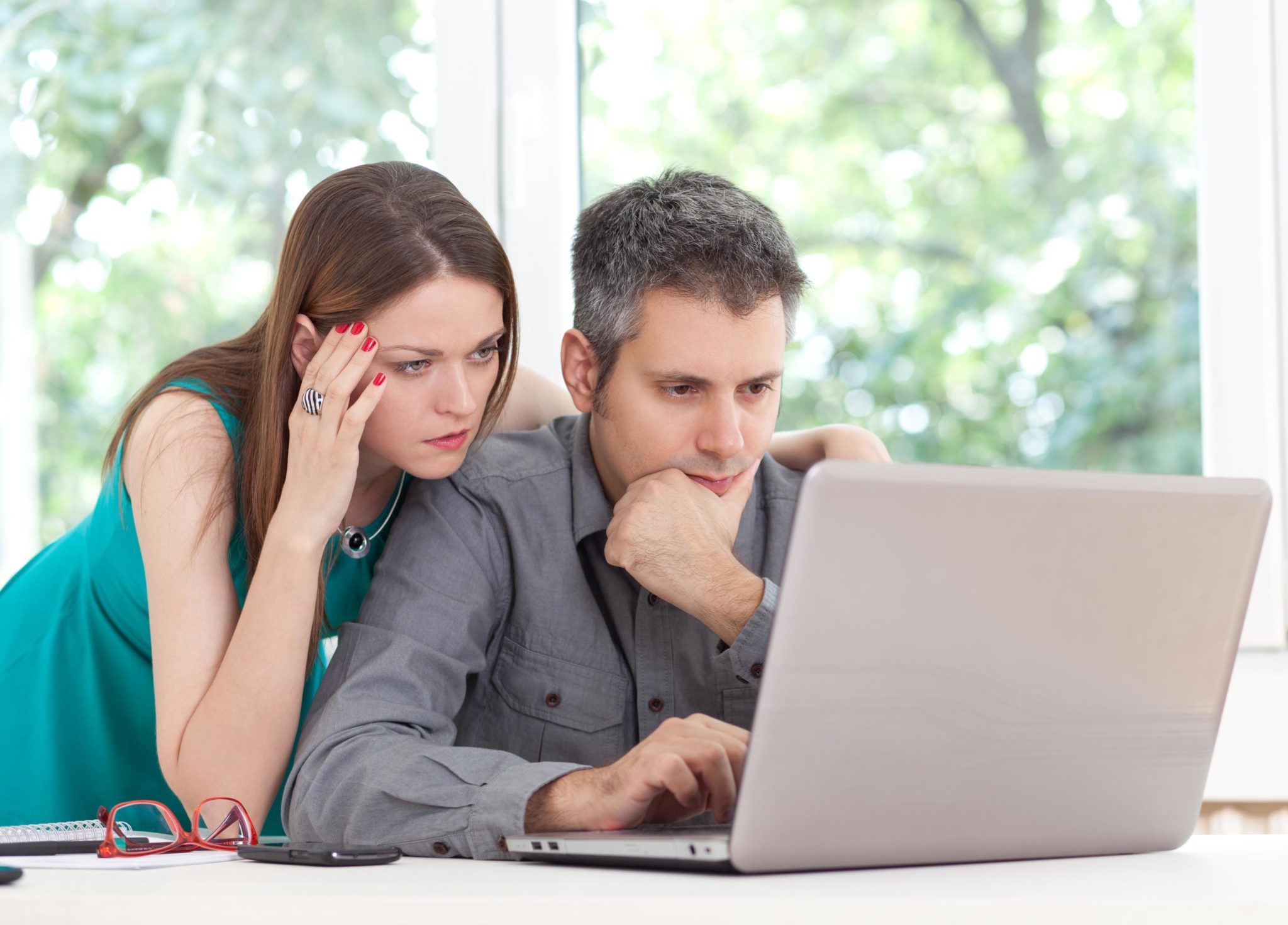 man and woman looking at laptop screen