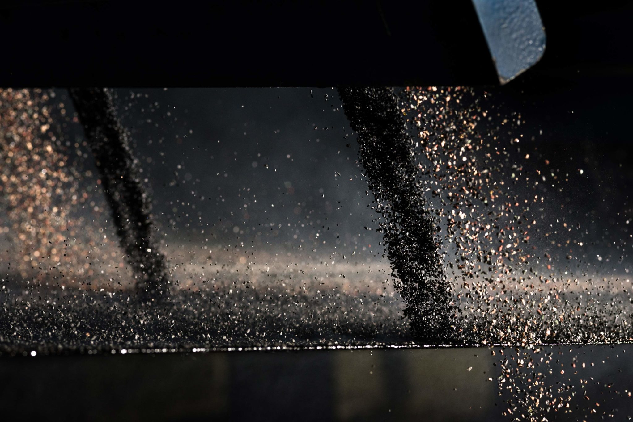 roofing granules falling onto an asphalt sheet