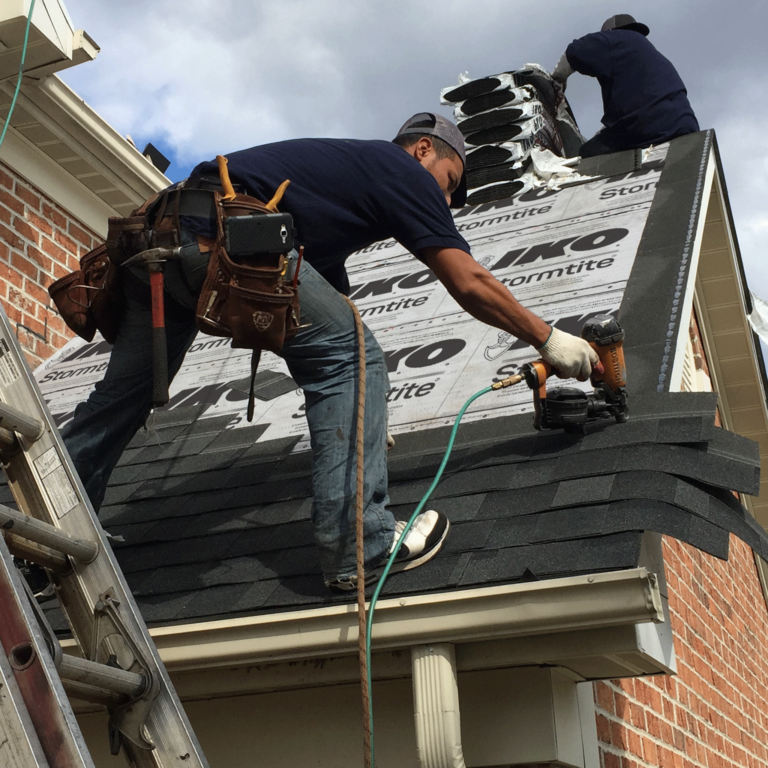 Roofers installing IKO Dynasty shingles on a roof