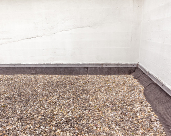 gravel placed on top of flat commercial roof - corner walls
