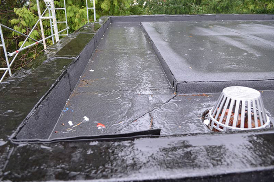 wet Commercial Roof and drain during rain