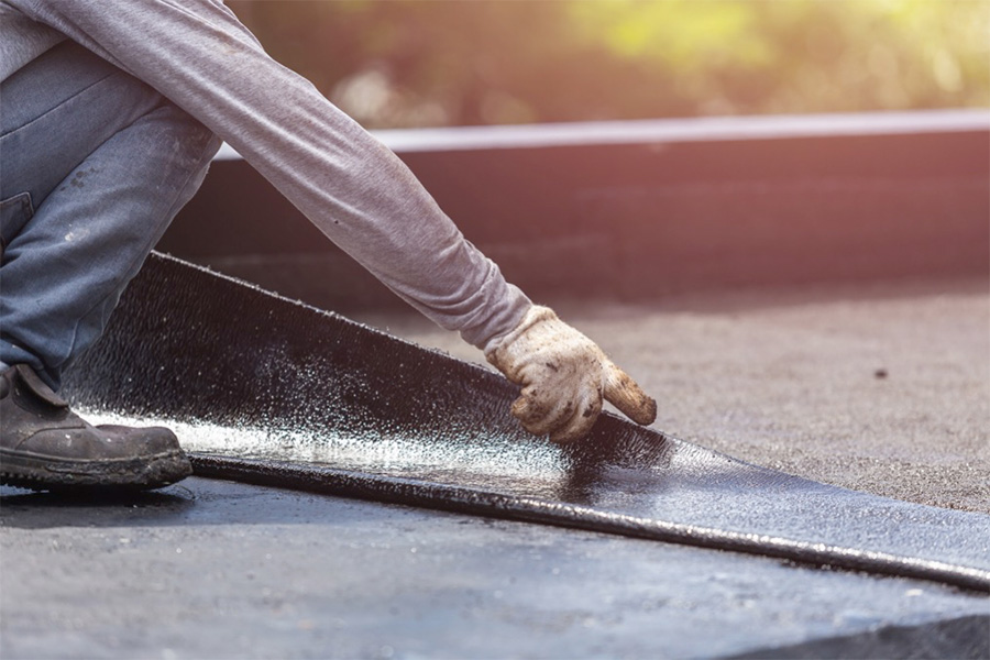 Roofer laying down a Base Sheet