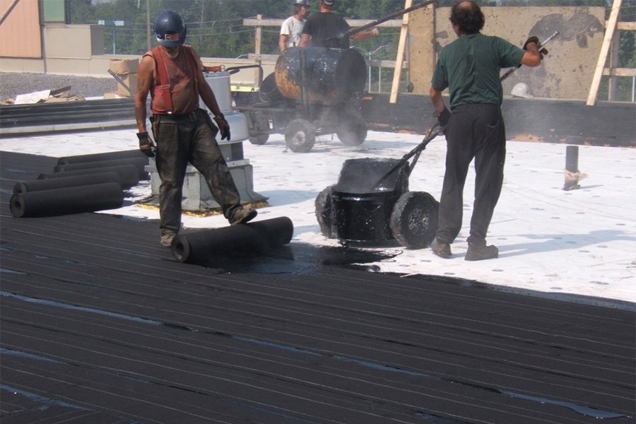 Roofers hot mopping a Built Up roof