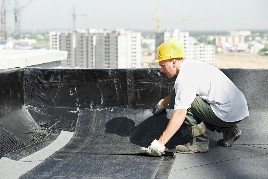 Roofer insatlling Base Sheet memebrane on low slope commercial roof