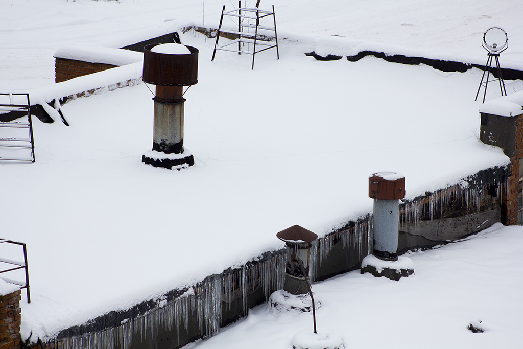 snow and ice buildup on commercial flat roof