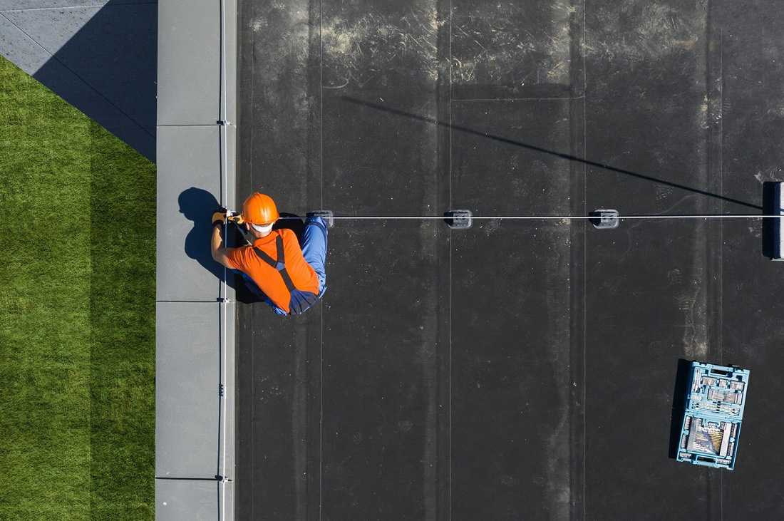 technician installing a lightning protection system on a flat roof