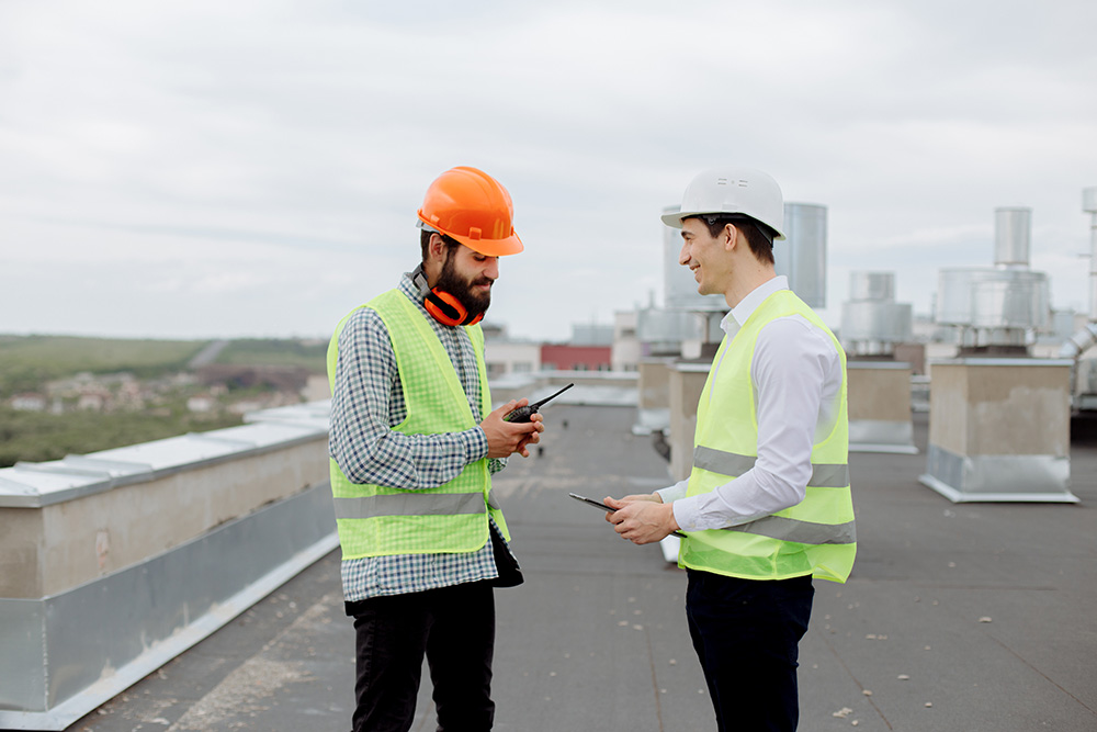 Two men talking about commercial roofing with smiley faces