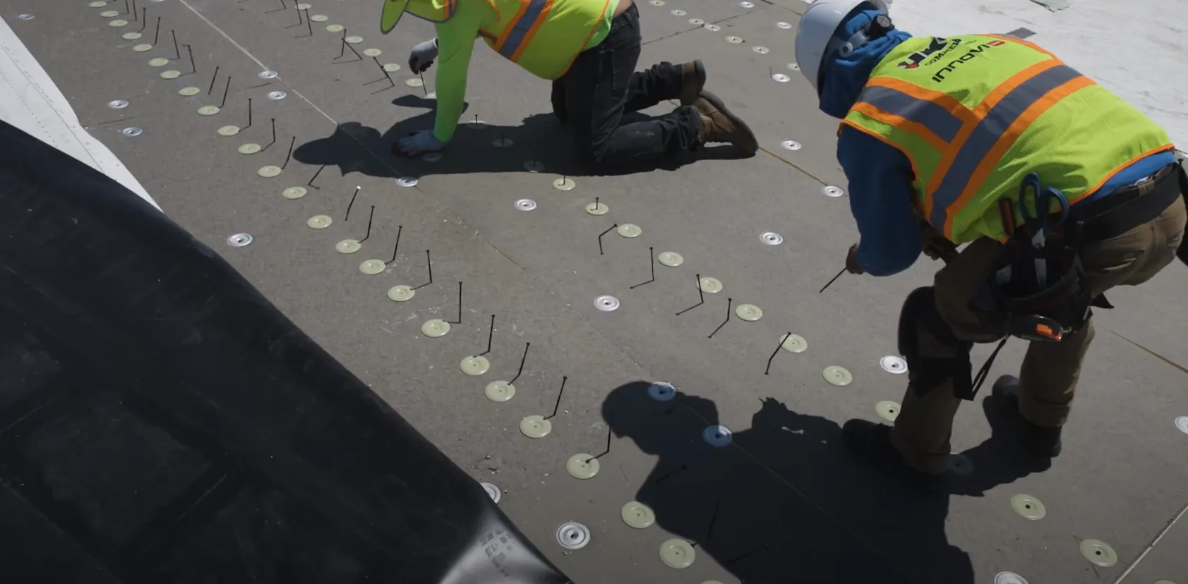 IKO InnoviFast fasteners and plates being added to a TPO roof installation.