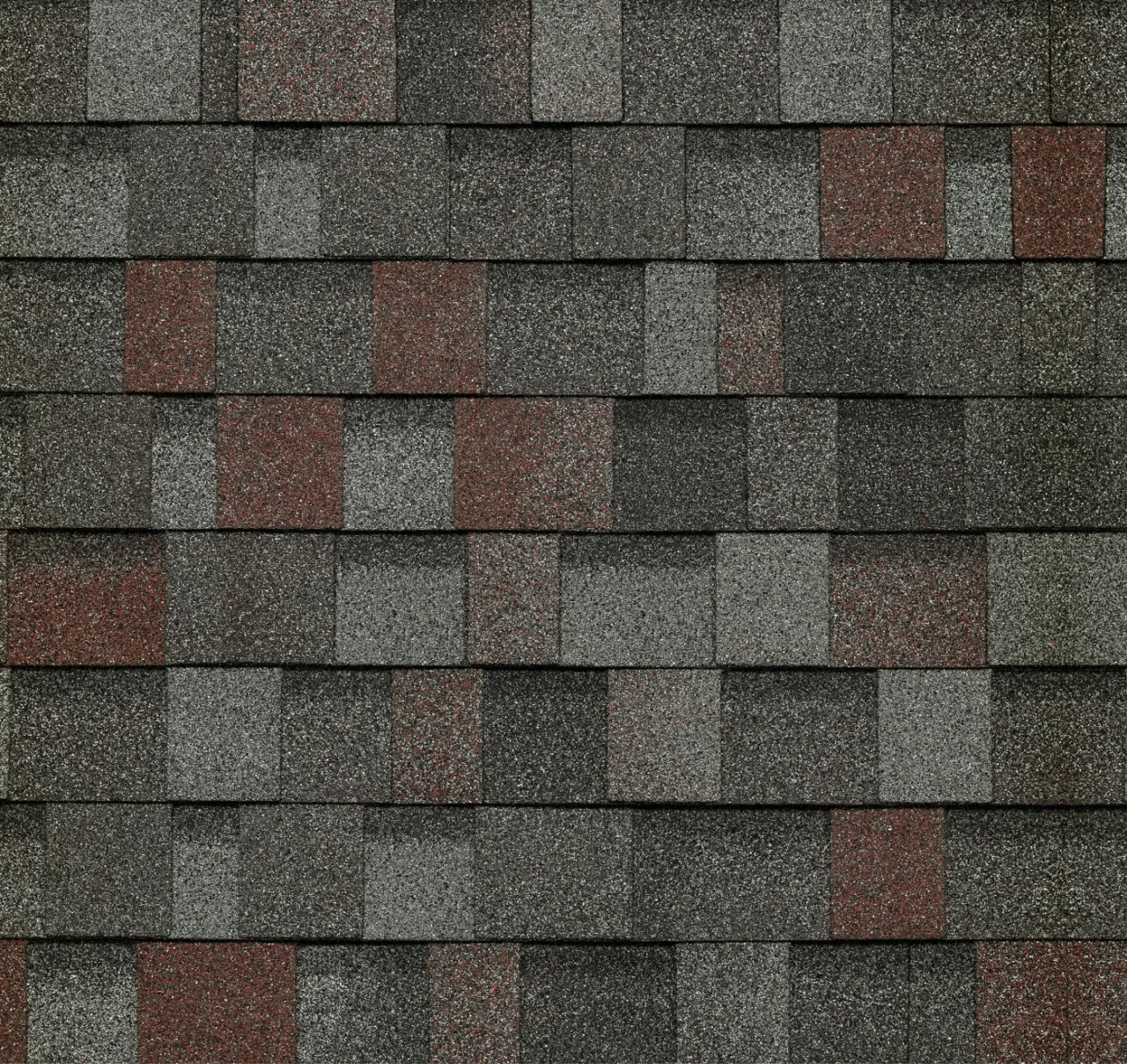 Gros plan d'une toiture avec bardeaux d'asphalte gris et rouges en alternance, rappelant les motifs élégants d'un design Dynasty ardoise.