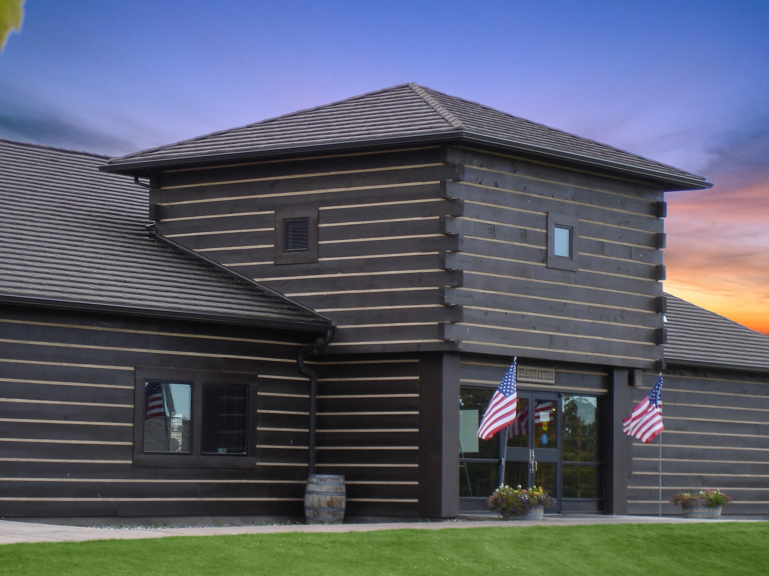DECRA shake-profile metal roof on a log cabin-style headquarters building at sunset