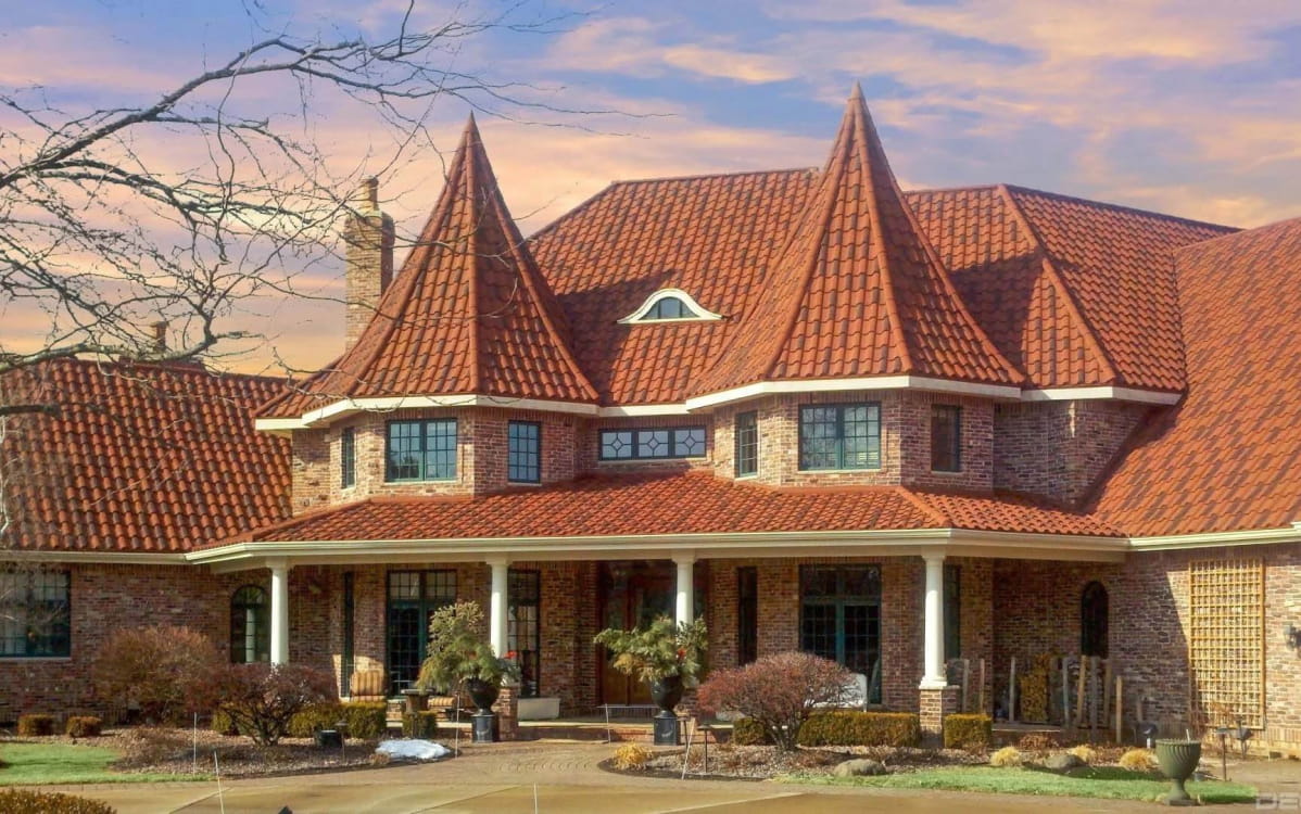 DECRA Spanish-Style Barrel Tile on a luxury brick house highlighting stone-coated steel barrel tiles and Mediterranean curves