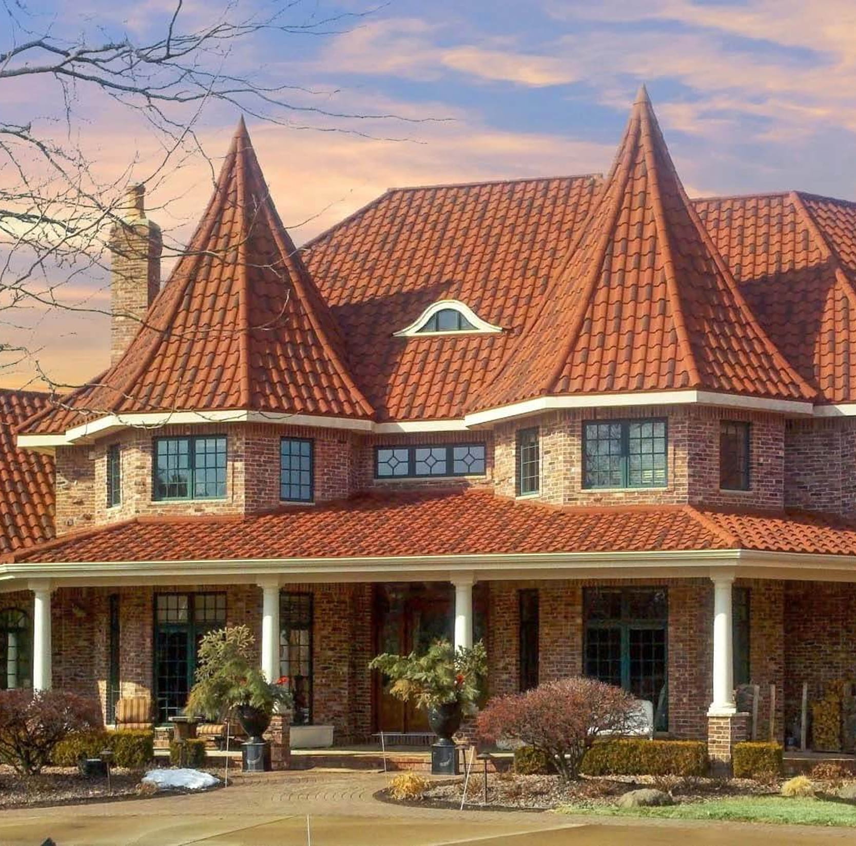 DECRA Spanish-Style Barrel Tile on a luxury brick house highlighting stone-coated steel barrel tiles and Mediterranean curves