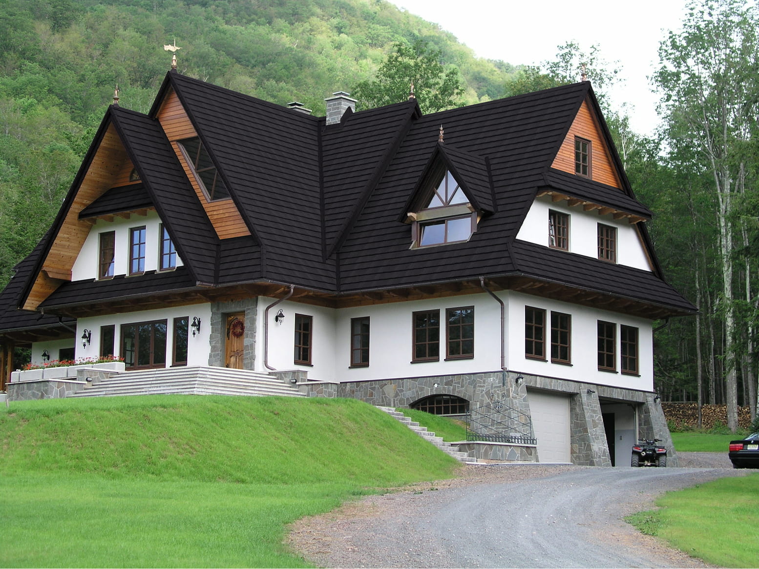 DECRA Farmhouse Shake Blacksmith Catskill NY metal roof on a hillside chalet with dark textured shake tiles and white facade