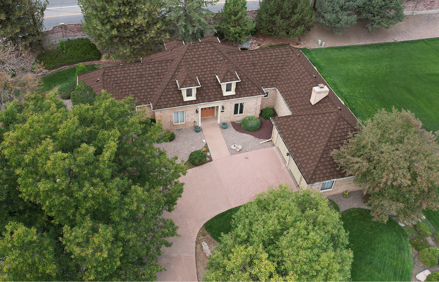 Aerial shot of a home with DECRA Farmhouse Shake Finished Oak stone-coated steel roof mimicking natural cedar shake texture