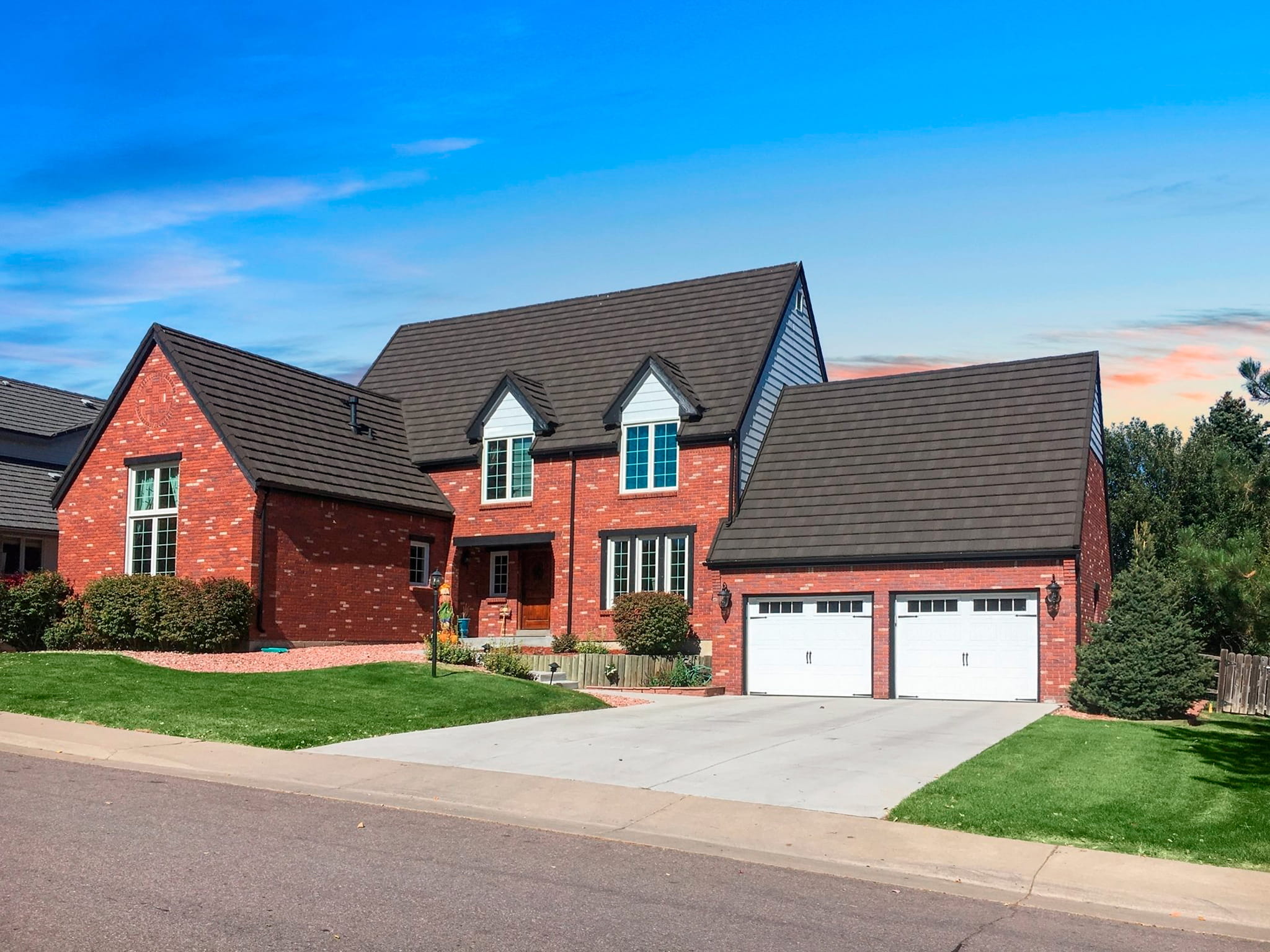 DECRA Farmhouse Shake Walnut stone-coated steel roofing on brick house, highlighting shake look and long-lasting performance