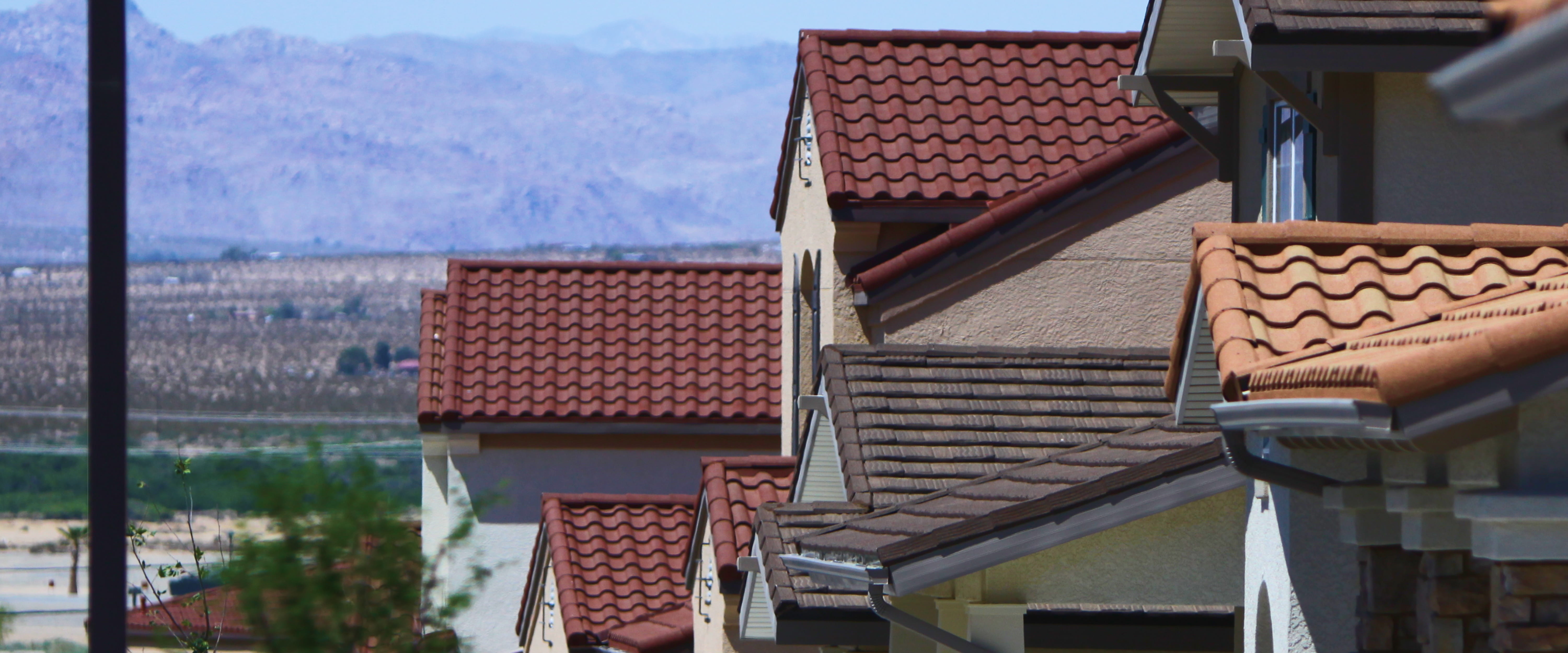 Desert neighborhood close-up of DECRA metal tile roofs in terracotta and brown with stone-granule finish and Spanish profile