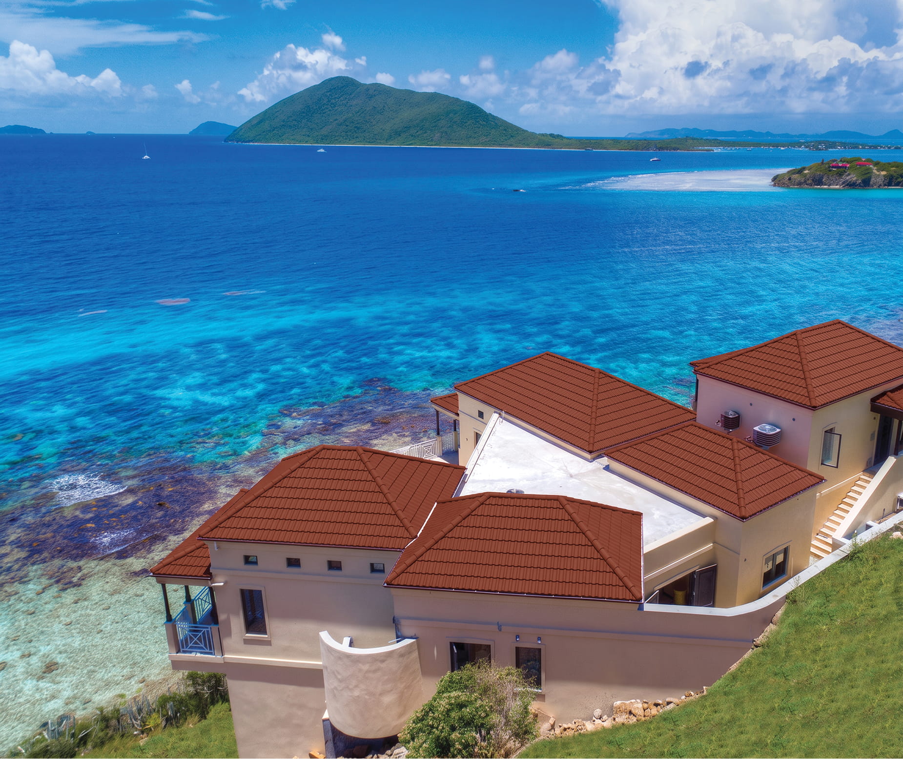 DECRA Mediterranean Tile Canyon Terra on coastal villas with red-brown tile profile and bright turquoise ocean backdrop