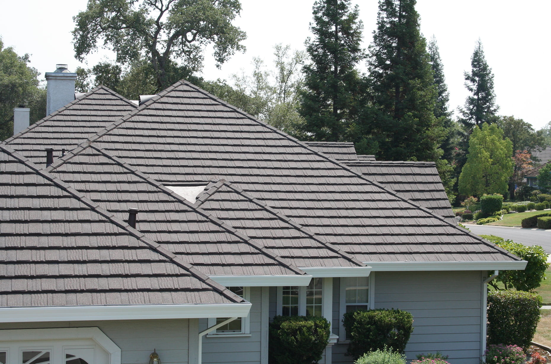 DECRA gray stone-coated steel shingle roof on a suburban single-story home showcasing textured tile-look metal roofing panels
