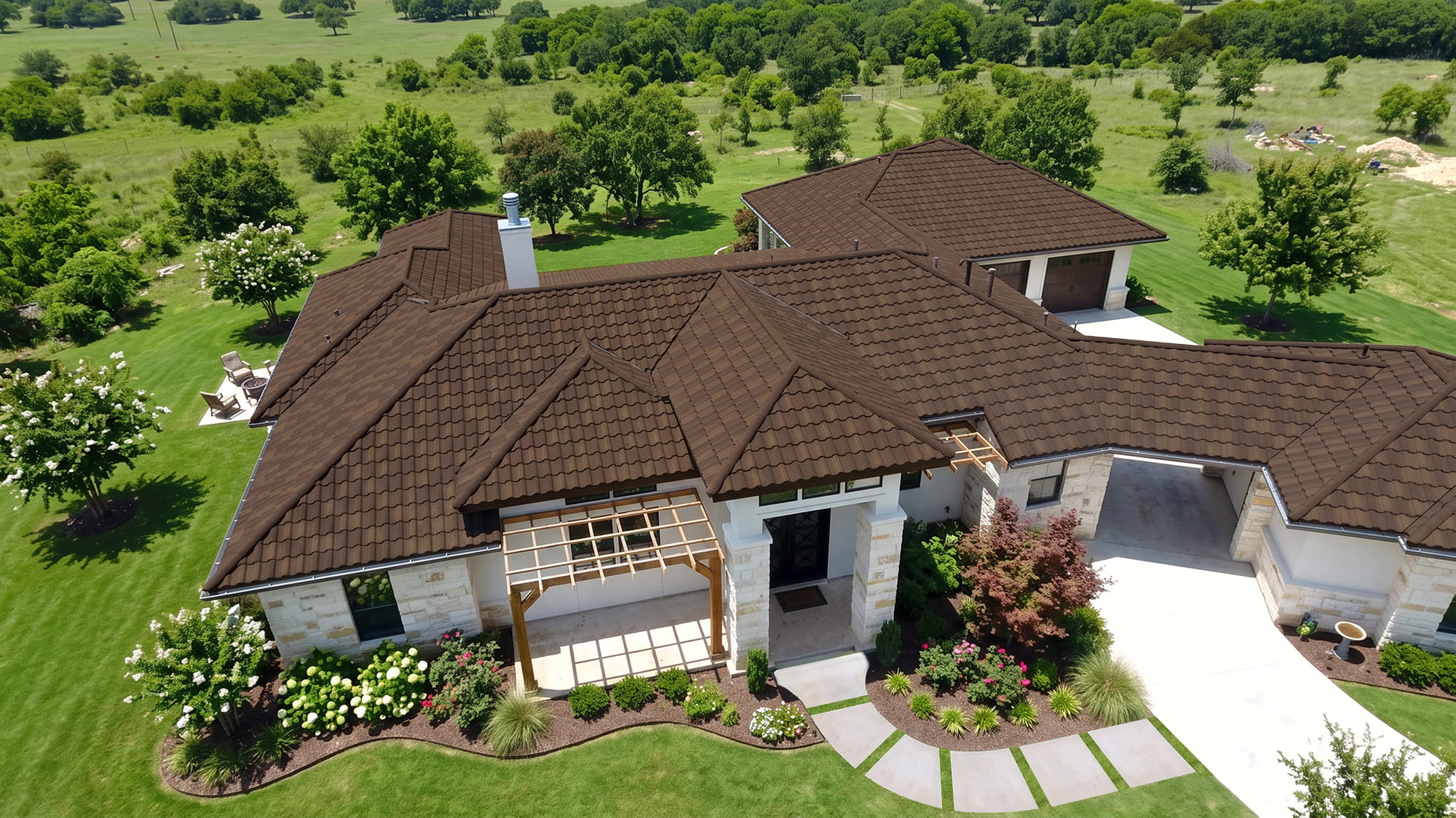 DECRA Spanish Tile roof in Bronzed Oak installed on a luxury home with manicured landscaping and green countryside views