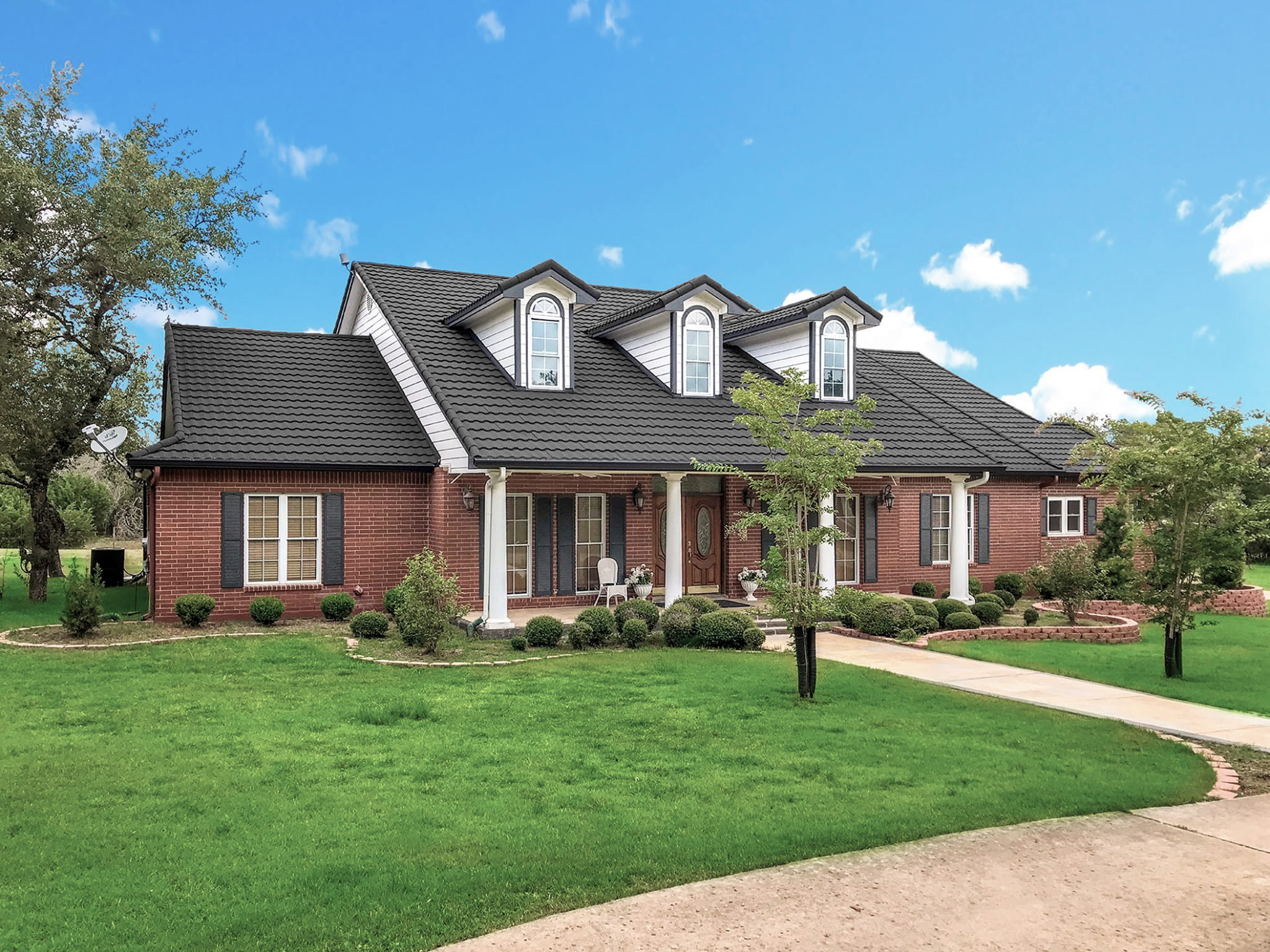 DECRA Mediterranean Tile Carbon stone-coated steel roof on a brick home, Mediterranean tile aesthetic with lasting protection