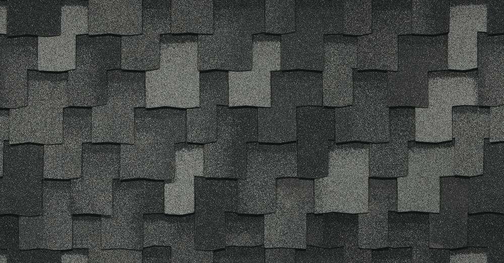 Vista cercana de tejas asfálticas Armourshake gris oscuro superpuestas con superficie texturizada, que muestran la calidad superior del techado Greystone.