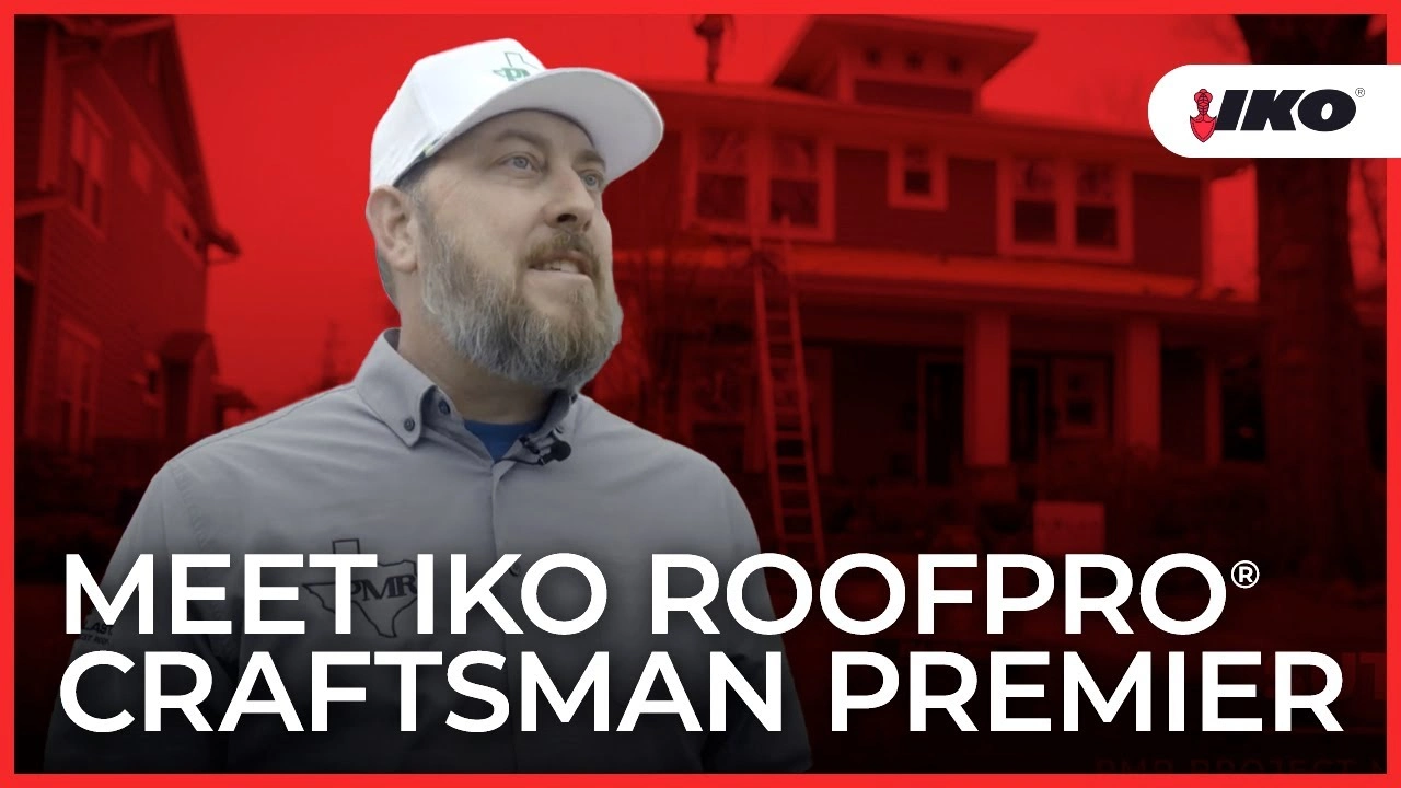 A person in a cap and uniform stands proudly in front of a house, showcasing their prowess as an IKO ROOFPRO Craftsman Premier. The company logo is prominently displayed, ensuring instant recognition for quality and expertise.