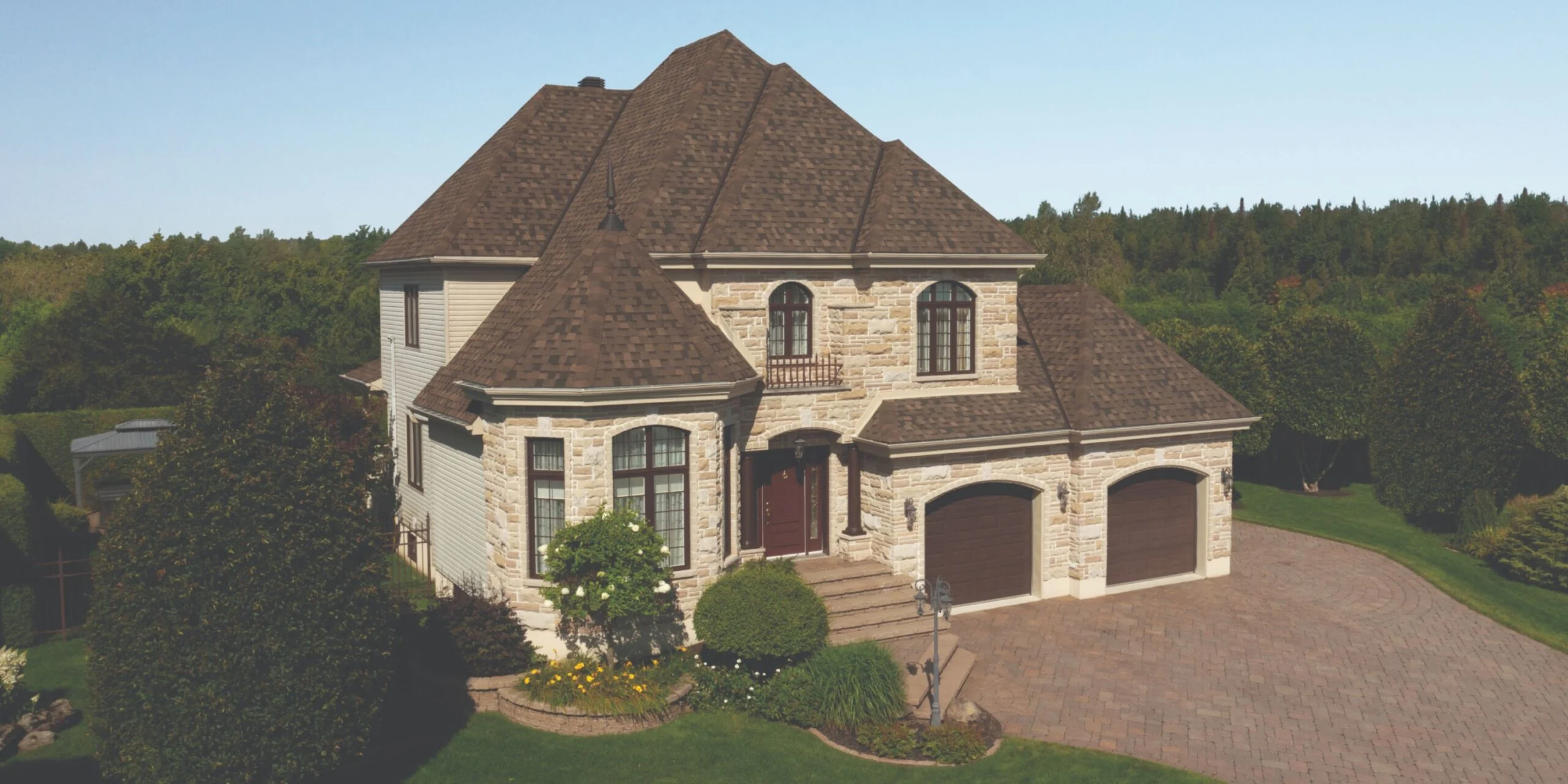 Light colored home, tan brick, with dark roof, brown shingles