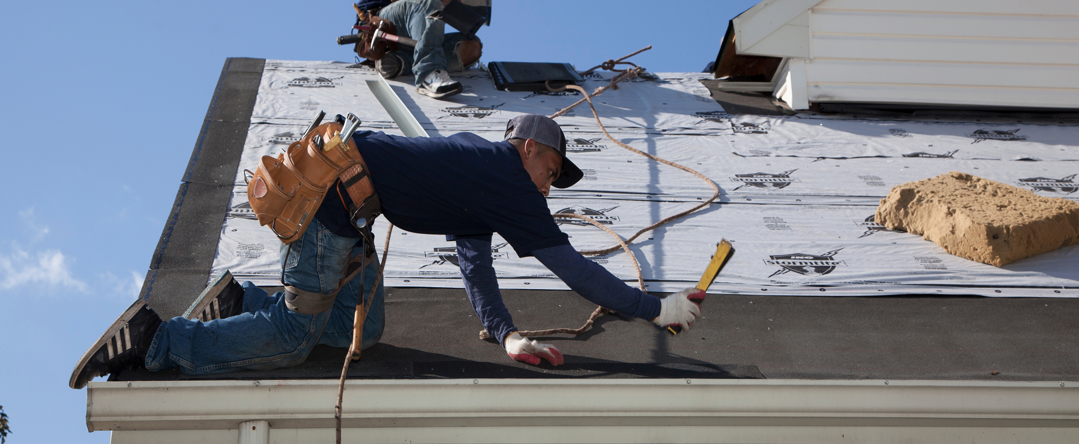 New asphalt shingles being installed across a sloped residential roof