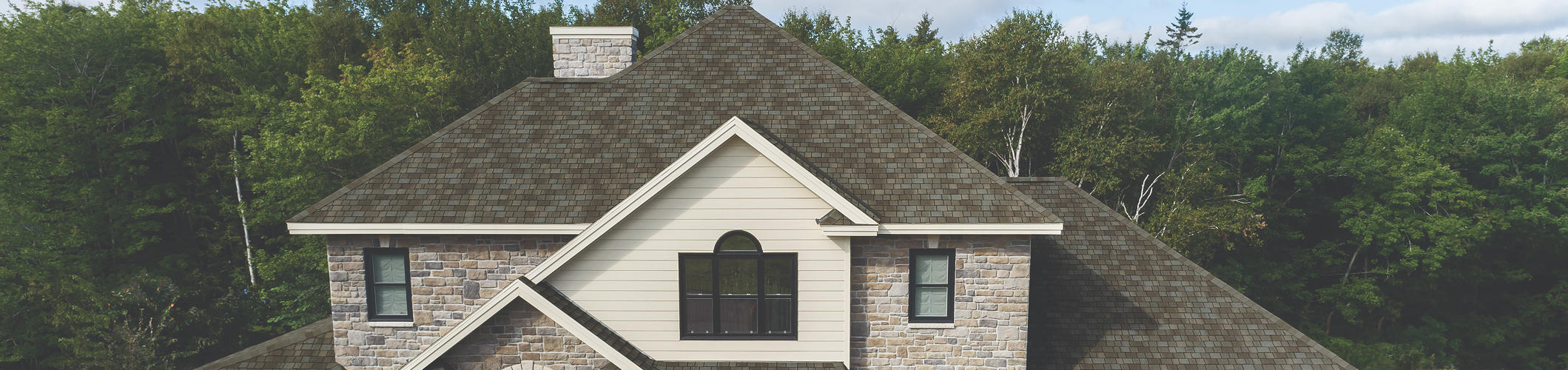 House with designer shingles featuring a high-end architectural roof style.