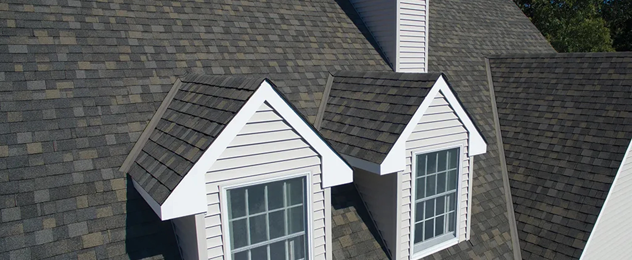 Close up of dark shingles on a white house