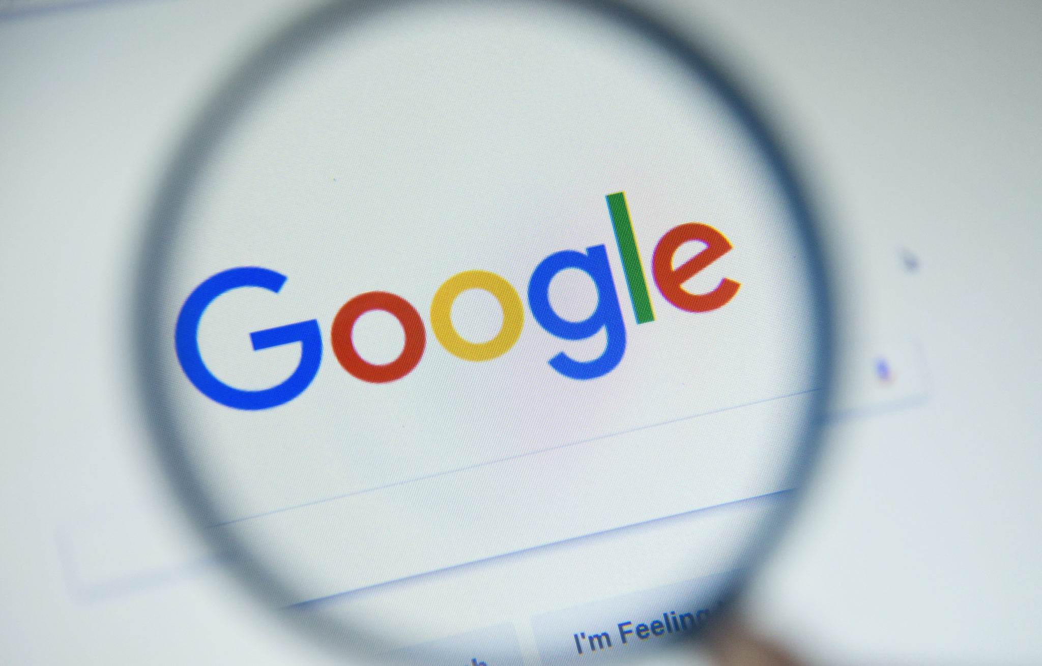 Magnifying glass over the Google search page showing the Google logo.