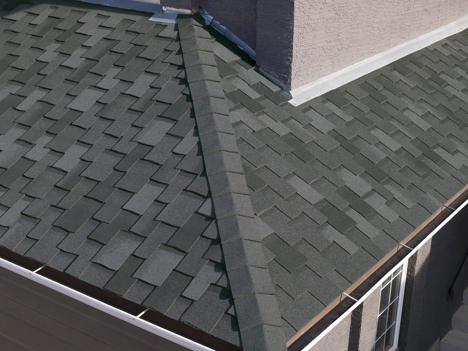 Roof valley and chimney covered with dark gray Armourshake Ultra HP shingles in Shadow Black