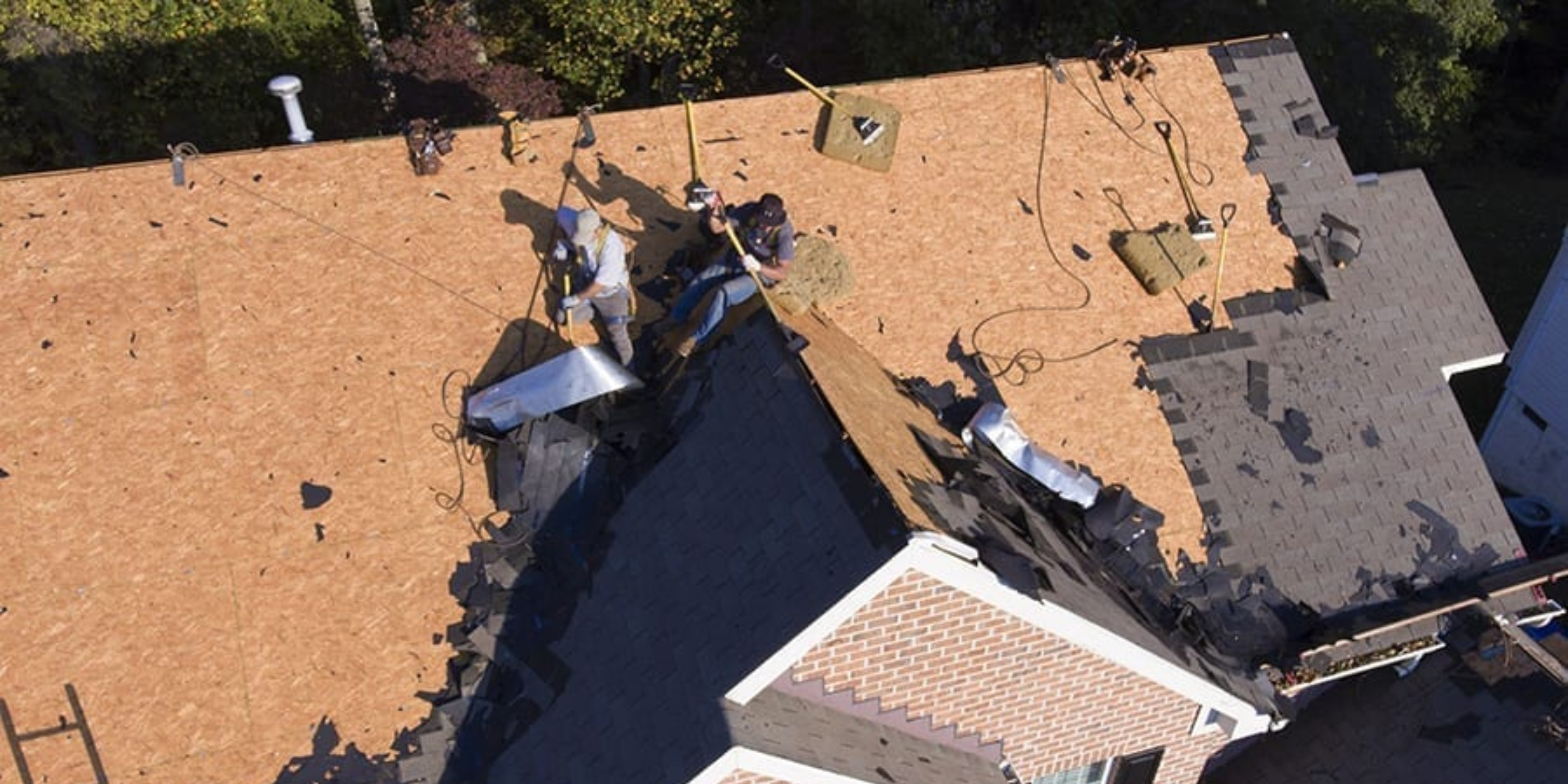 Roofers removing shingles from roof