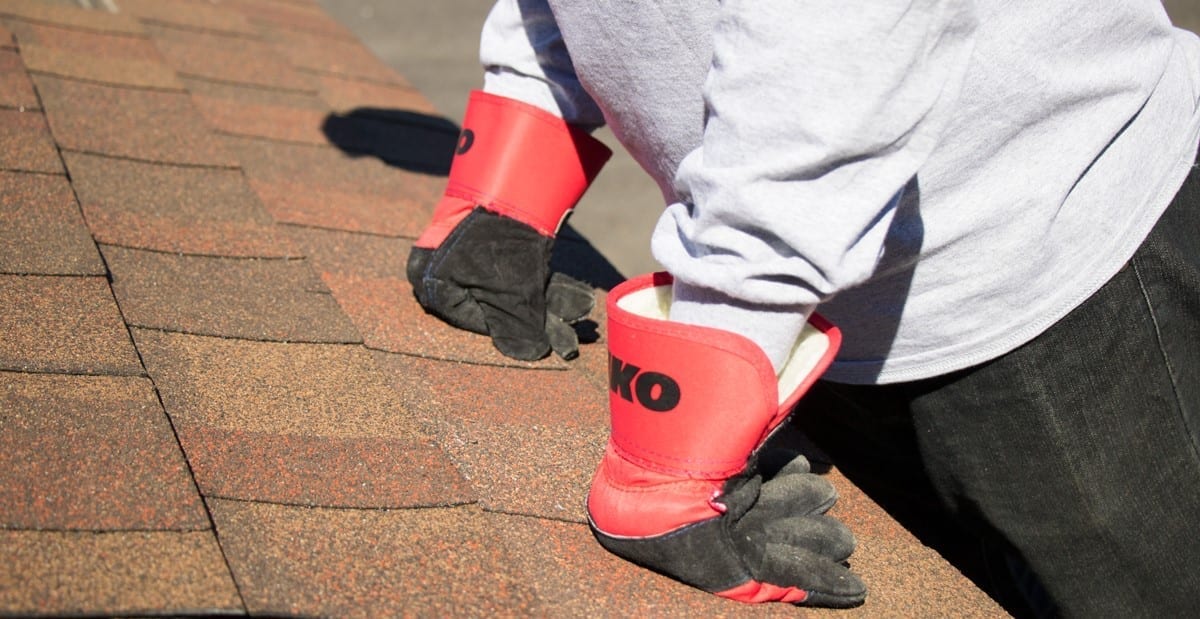 trabajador de tejado sujetando tejas laminadas
