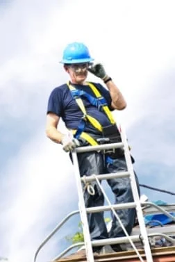 roofer on the rooftop next to a ladder