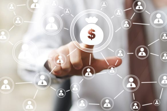 Business person touching a glowing money bag icon connected to a network of people icons