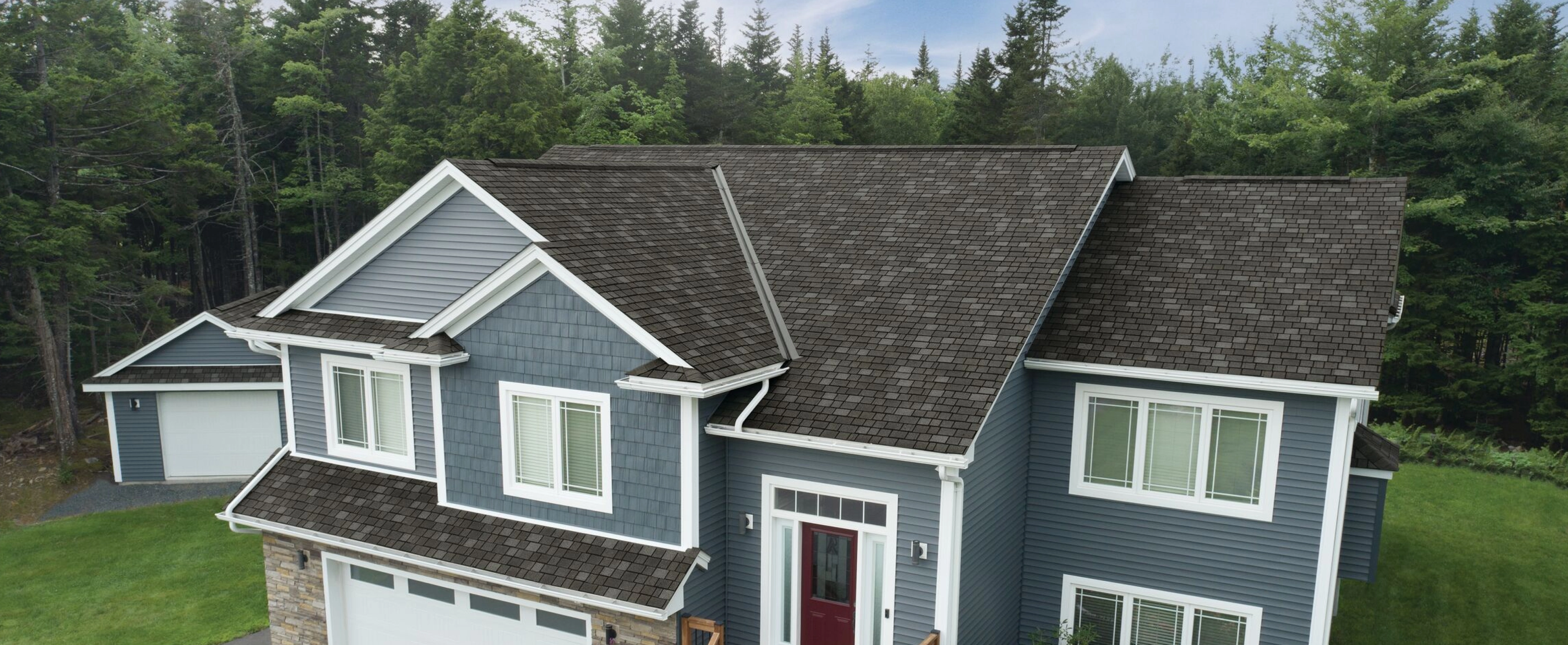 A large blue home with dark grey IKO shingles on the roof.