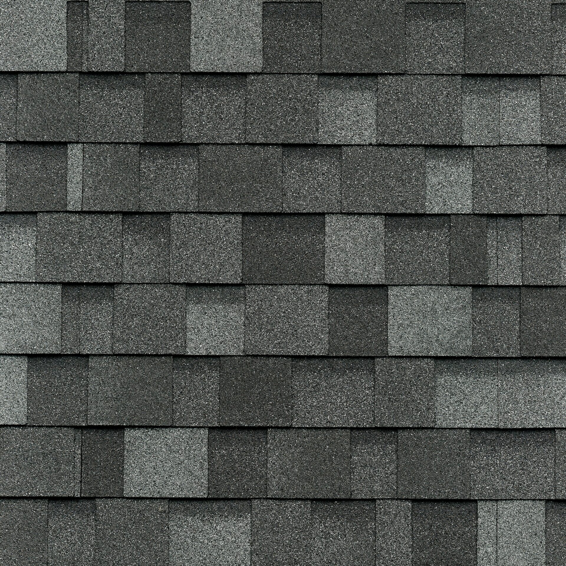 Gros plan d'une toiture de bardeaux d'asphalte gris foncé de style Cambridge, ressemblant à l'ardoise classique avec son motif rectangulaire uniforme et sa surface texturée.