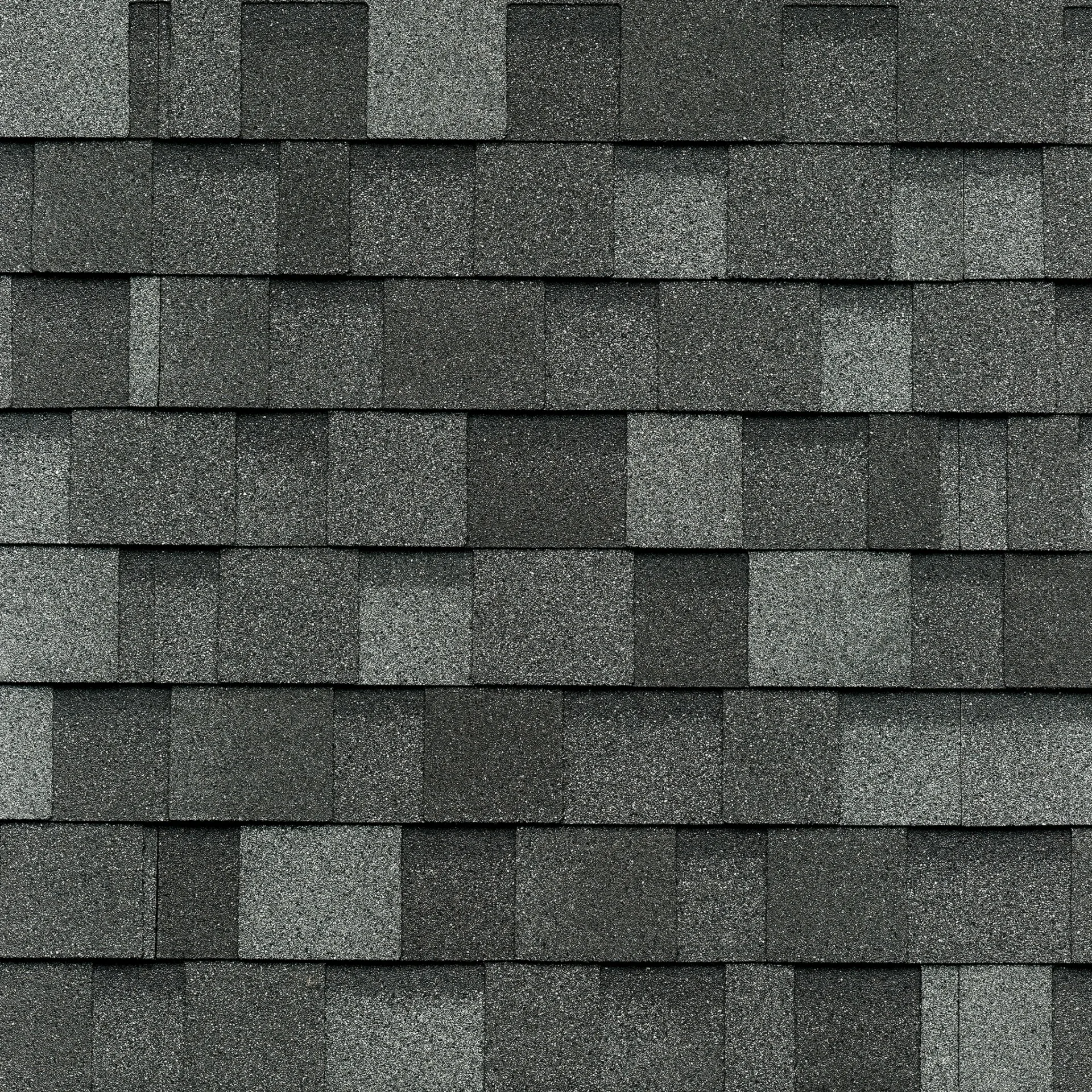 Gros plan d'une toiture de bardeaux d'asphalte gris foncé de style Cambridge, ressemblant à l'ardoise classique avec son motif rectangulaire uniforme et sa surface texturée.