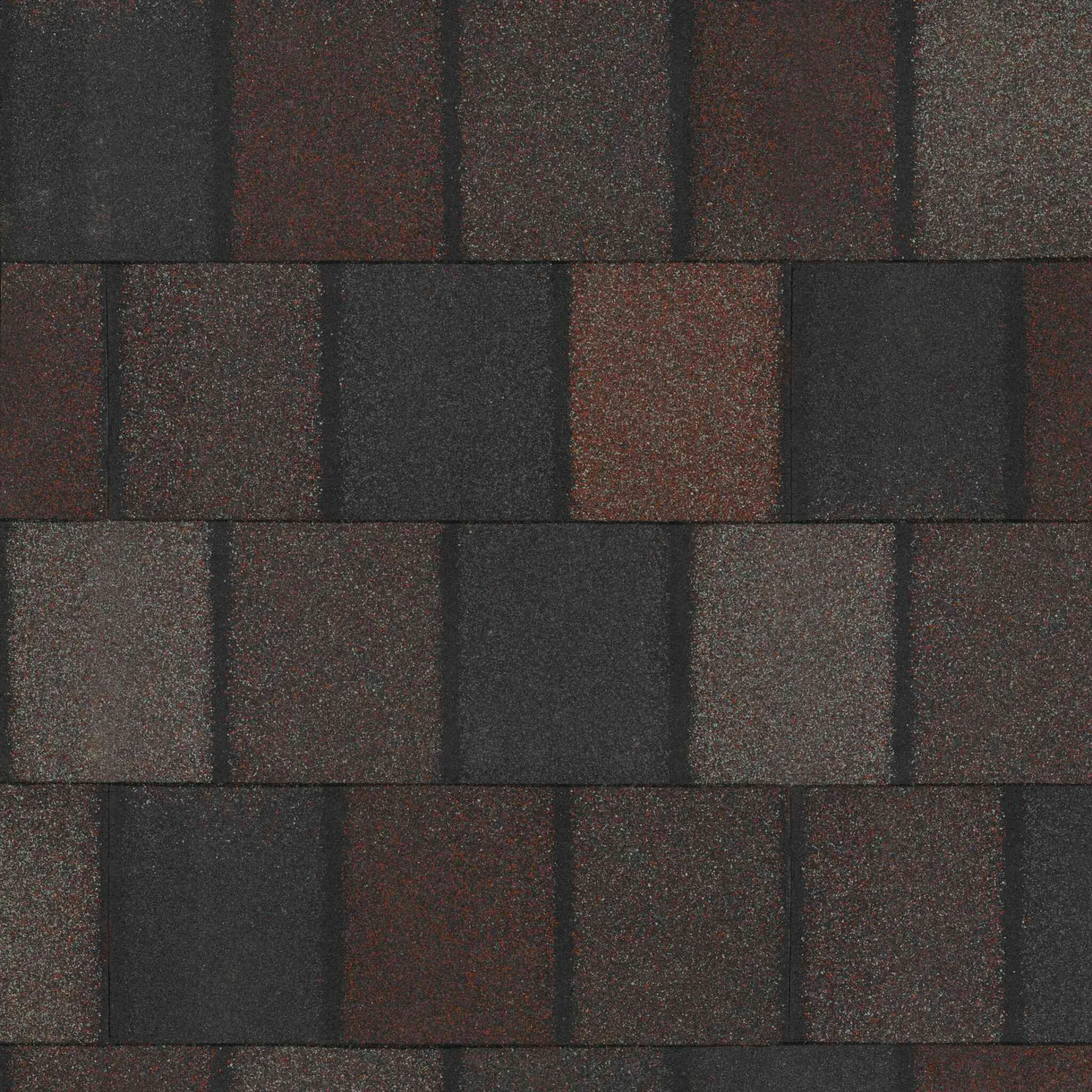 Tejas de techo asfálticas en tonos de gris oscuro y marrón, que recuerdan Royal Granite, dispuestas en un patrón repetitivo.