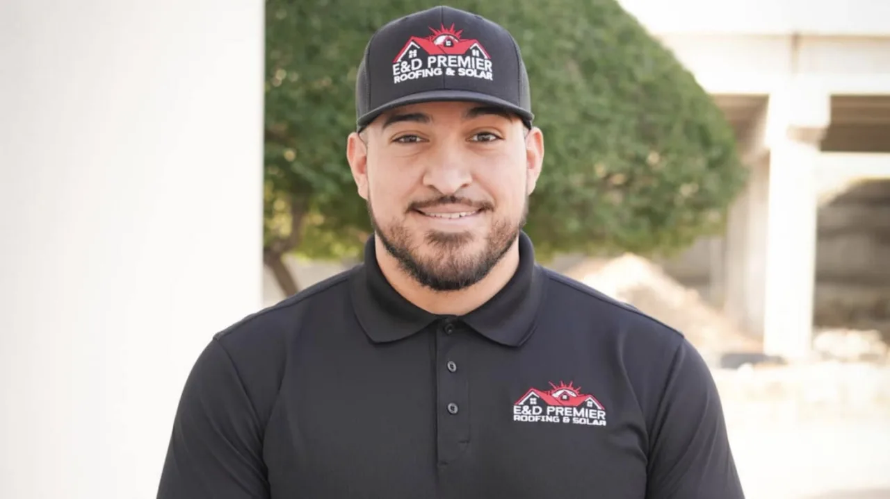 Un hombre con polo negro y gorra con el logotipo de ROOFPRO está de pie al aire libre frente a un fondo desenfocado, mostrando las ventajas de los servicios de techado expertos.
