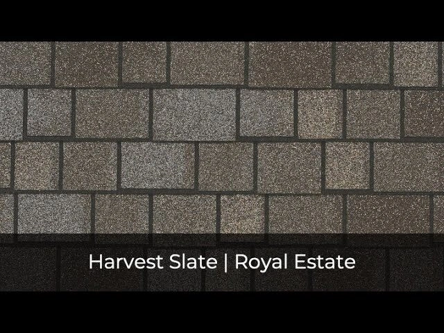 Primer plano de una superficie de techado texturizada con tejas rectangulares marrones y grises de los colores IKO, con la etiqueta «Harvest Slate | Royal Estate».