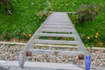 extension ladder leaning on gutter - downward view