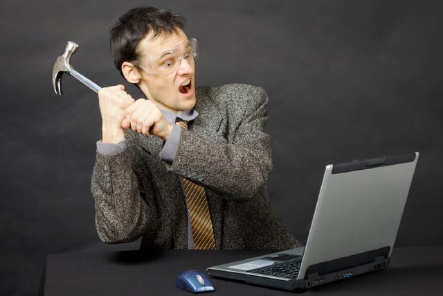 man smashing laptop with hammer