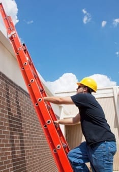 man climbing up an extension ladder 