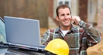 roofer on call with client while looking at his laptop 