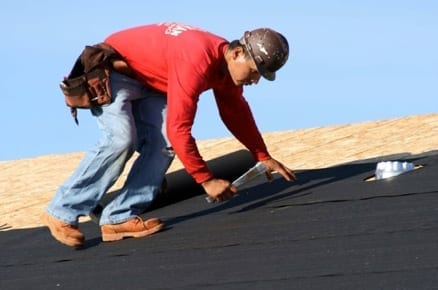 roofer stapling felt to a sloped roof