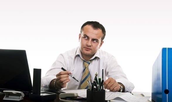 man at office desk thinking