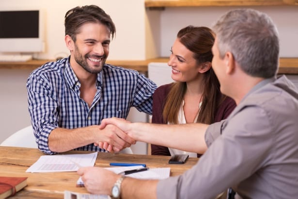 couple signing agreement with roofing contractor