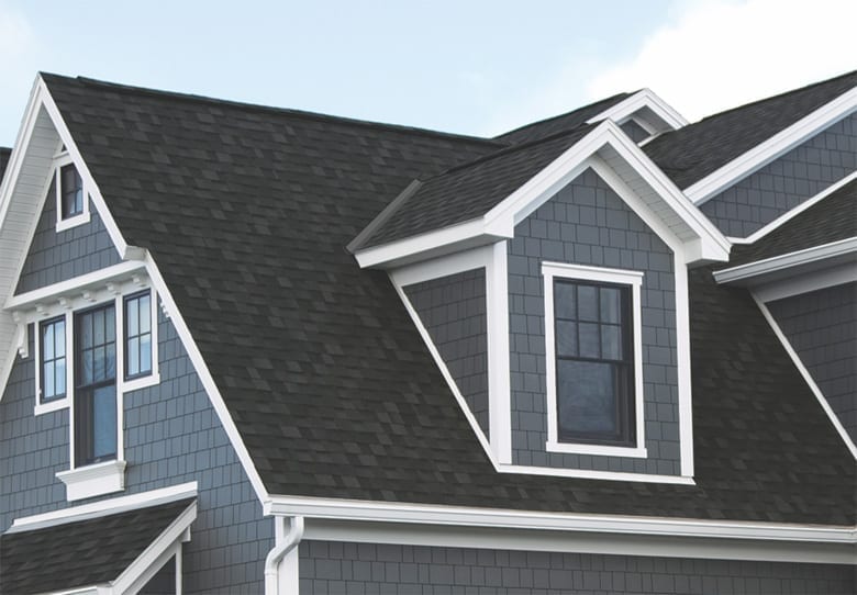 home with blue exterior walls and black laminated shingles